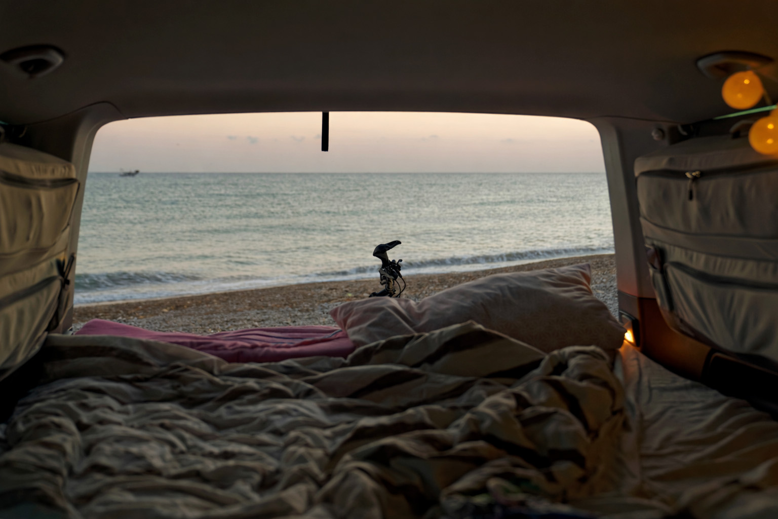 Camper am Strand mit geöffnetem Kofferraum